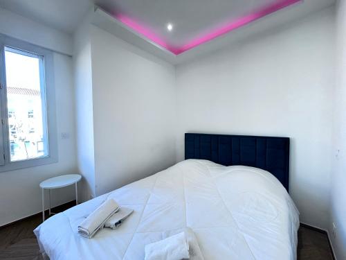 Un dormitorio con una cama grande con dos toallas encima. en AmoreMio - 4 pers Neuf- Hyper centre - Terrasse, en Saint-Raphaël