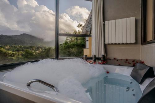 a bath tub filled with snow in front of a window at Mirante da Colyna Hotel & SPA in Monte Verde