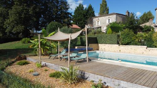 una piscina con due sedie e un ombrellone e un tavolo di Gîtes de Charme Lalaurie a Sauveterre-la-Lémance