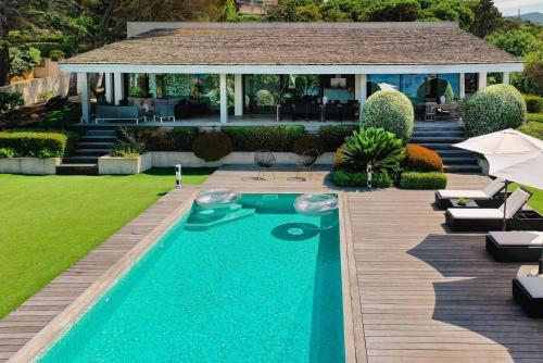 une cour arrière avec une piscine et une maison dans l'établissement VILLA GIRELLES- pieds dans l'eau, piscine, vue mer, 5 chambres, à Pietrosella