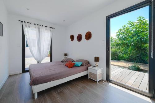 une chambre avec un lit et une grande fenêtre dans l'établissement VILLA GIRELLES- pieds dans l'eau, piscine, vue mer, 5 chambres, à Pietrosella