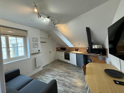 un salon avec une table et une cuisine dans l'établissement Appart T2 cosy - 4 pers - Centre Baugé, à Baugé