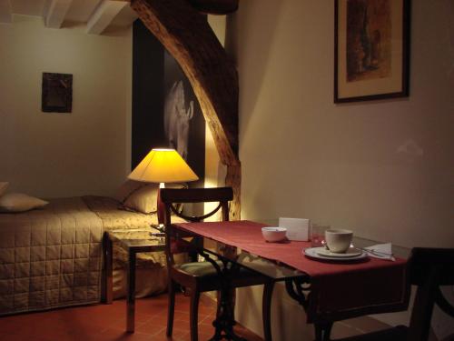 Habitación con mesa, cama, mesa y sillas. en Aparthotel De Beek Anno 1410, en Sint-Truiden
