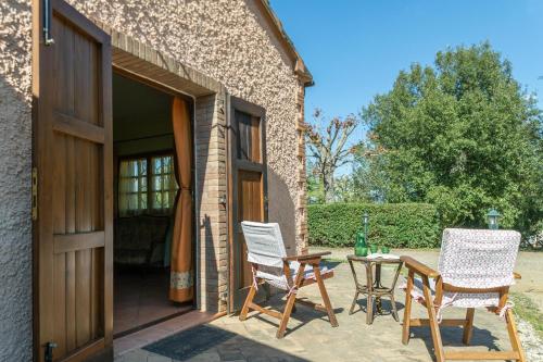 a patio with chairs and a table and a door at Flores in Roccastrada