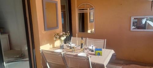 mesa con sillas y mantel blanco en Ciel Bleu de Cannes - Appartement Vue Azur avec Piscines et Jardin, en Cannes