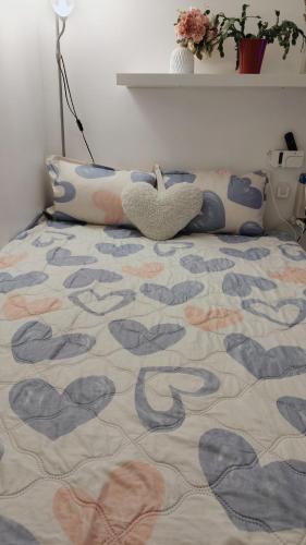 - une chambre avec un lit doté d'un couvre-lit et de coeurs dans l'établissement centre villeOpéra, Gare st Lazare , cozy studio, à Paris