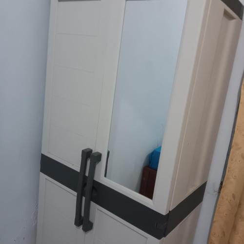 a white cabinet with black handles in a room at Graha Azzam House in Sidoarjo