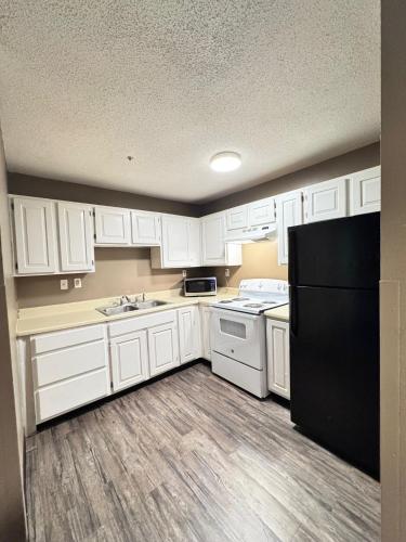 a kitchen with white cabinets and a black refrigerator at Live In Lodge Marietta in Marietta