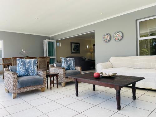 a living room with a couch and chairs and a table at The Golf House 7 in Blythedale