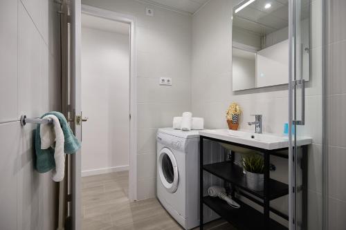 a bathroom with a washing machine and a sink at BBarcelona Gracia Apartment in Barcelona
