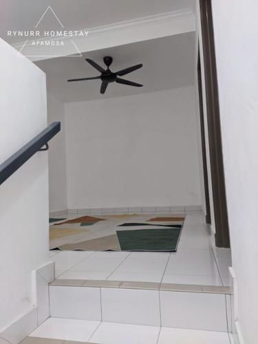 a staircase with a ceiling fan in a room at Rynurr Homestay A Famosa near Waterpark in Kampong Pulau Sebang