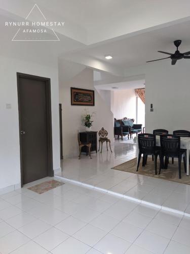 a living room with black chairs and a table at Rynurr Homestay A Famosa near Waterpark in Kampong Pulau Sebang