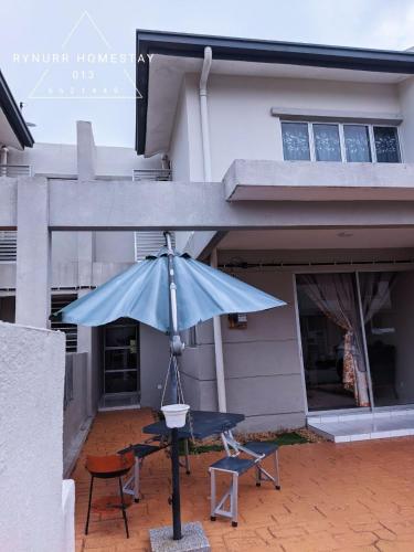a blue umbrella in front of a house at Rynurr Homestay A Famosa near Waterpark in Kampong Pulau Sebang