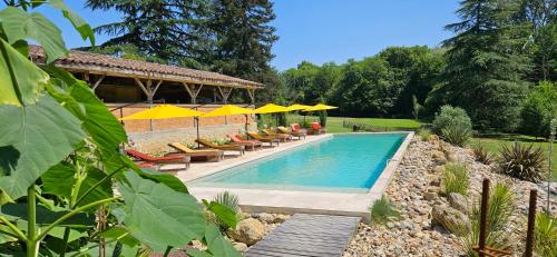 une piscine avec chaises et parasols dans l'établissement Château la bastide cardan, à Saint-Sulpice-de-Pommiers