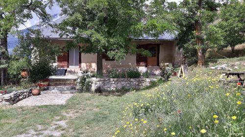 une maison avec une cour fleurie devant elle dans l'établissement Corps de garde de la Roche, à Mont-Dauphin
