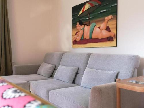 a living room with a gray couch and a painting at Chalet beim Georgi Schloss in Ehrenhausen