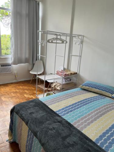 a bedroom with a bed and a chair and a window at Praia de Botafogo vista Pão de Açúcar in Rio de Janeiro