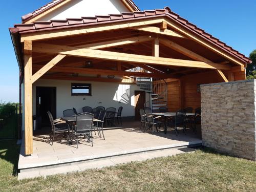 a wooden pavilion with tables and chairs on a patio at Penzion Dvojka in Velké Bílovice