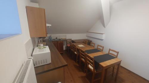 a dining room with tables and chairs and a kitchen at Penzion Staré Sedlo in Bor