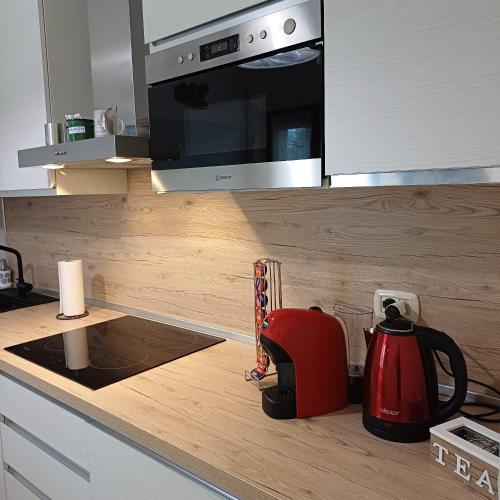 a red tea kettle on a counter in a kitchen at holiday home un piccolo angolo tra gnomi natura e relax in Tarvisio