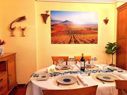 a dining room table with a picture of a vineyard at GarnachasBlancas in Haro