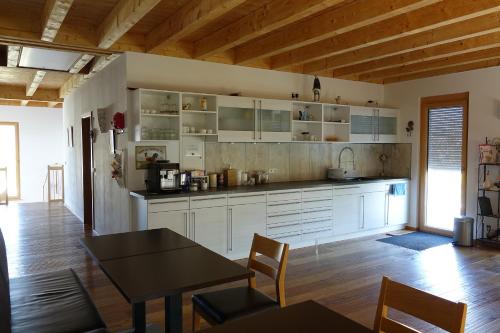 a kitchen with white cabinets and a table and chairs at Rooster BnB American Style Boutique Haus - made with Love! in Rust