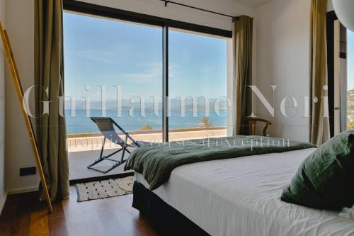 - une chambre avec une grande fenêtre donnant sur l'océan dans l'établissement VILLA CASADELMAR- 7 chambres, 16 personnes, vue mer, piscine, appartement, accès plage, terrain pétanque, à Coti-Chiavari