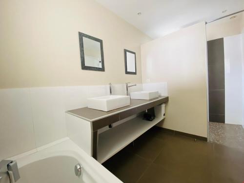 une salle de bain blanche avec deux lavabos et une douche dans l'établissement Villa Sauvage, à La Flotte