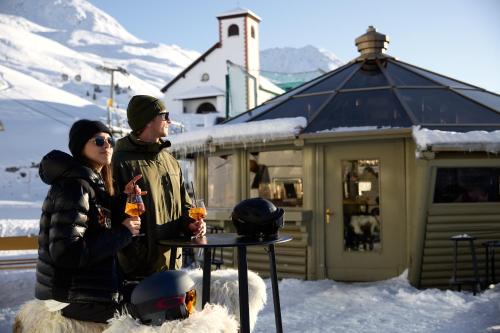 a man and a woman sitting at a table in the snow at TOP Hotel Hochgurgl in Hochgurgl
