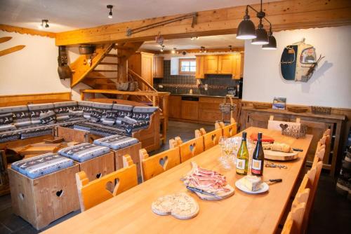 a dining room with a table and chairs and a kitchen at Chalet cosy pour 13 sauna in Saint-Martin-de-Belleville