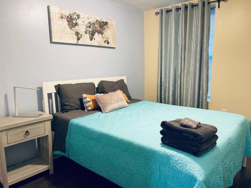 a bedroom with a bed with blue sheets and a window at Cozy Beautiful 2BD Apt in Center City in Philadelphia