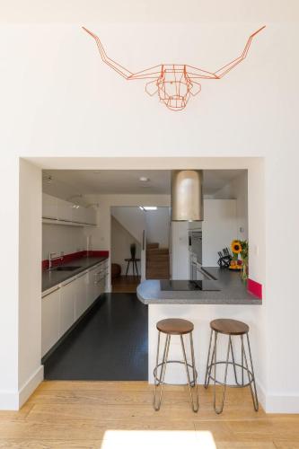 a kitchen with two bar stools and a counter top at Gorgeous home for 12 - Walk to Beach - Sea View in Chichester