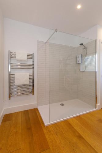 a bathroom with a glass shower with a window at Gorgeous home for 12 - Walk to Beach - Sea View in Chichester