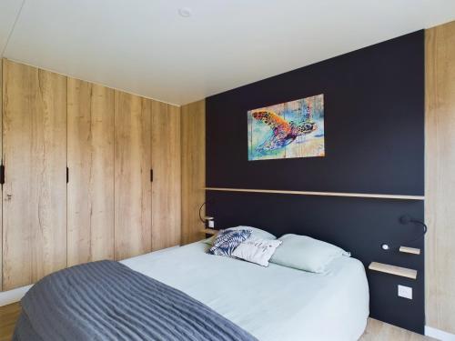 a bedroom with a bed and a black wall at Chalet moderne pour 6 - proximité des plages in Saint-Gilles-Croix-de-Vie