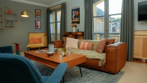 a living room with a couch and a table at Superbe appartement traversant 132m2, classé 5 étoiles, Sarlat centre in Sarlat-la-Canéda