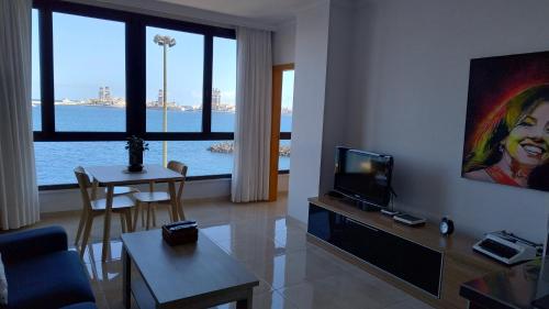 una sala de estar con televisión y una sala de estar con mesa en Casa Mina, en Las Palmas de Gran Canaria