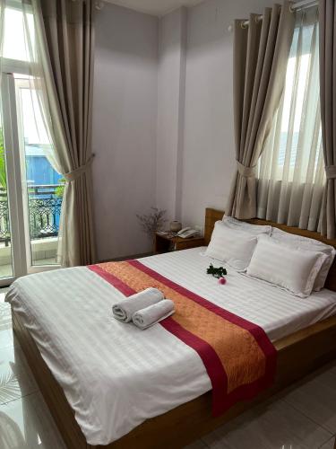 a bedroom with a bed with two towels on it at The Sun Hotel in Long Bình