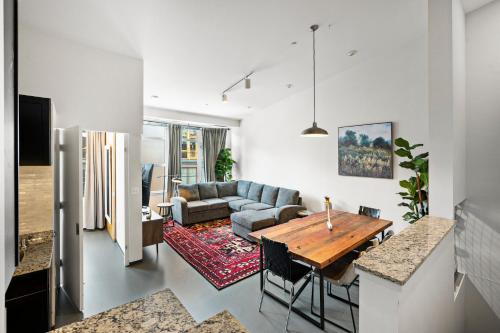 a living room with a table and a couch at Furnished Loft Style Apartment in Southend in Boston