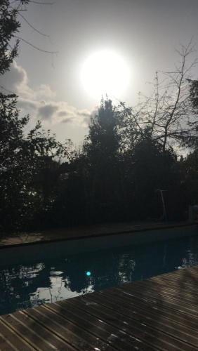 un bassin d'eau avec le soleil en arrière-plan dans l'établissement Maison pierre Bordeaux avec piscine chauffée, à Bordeaux