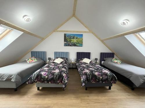 a room with three beds in a attic at Domek w Górach Wilkanów Park in Wilkanów
