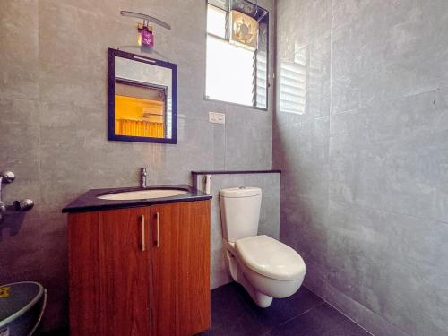 a bathroom with a toilet and a sink and a mirror at Private 3BHK Villa with Indoor Pool in Chengalpattu