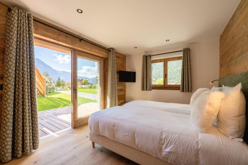 une chambre avec un lit et une grande fenêtre dans l'établissement Chalet Angel - Chamonix, à Chamonix-Mont-Blanc