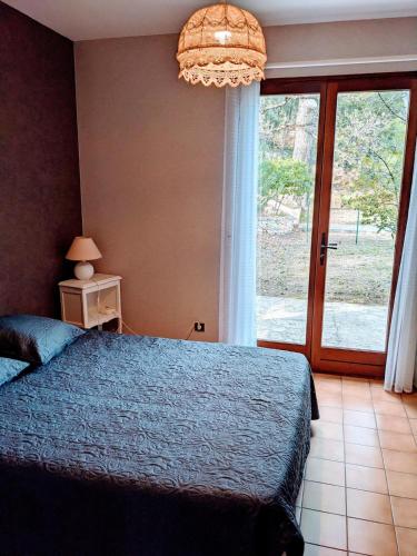 une chambre avec un lit bleu et une grande fenêtre dans l'établissement -Villa les Pins- Bandol, à Bandol