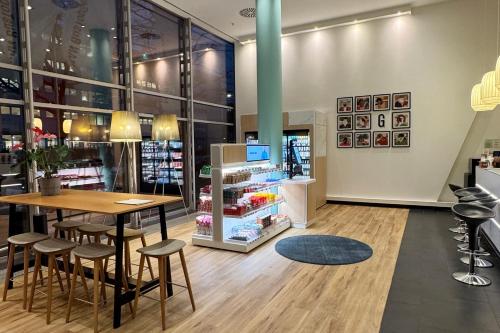 a restaurant with a table and stools in a store at Garner Hotel Berlin - Spandau by IHG in Berlin