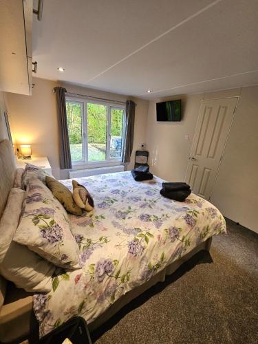 a bedroom with a bed with a blanket on it at Oak Tree Lodge with Hot Tub near Alton Towers in Croxden