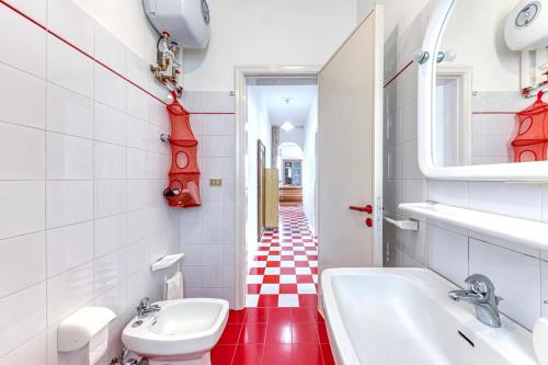 a bathroom with a red and white checkered floor at Le Carrube Vista Mare in Andrano