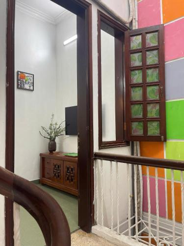 a room with a balcony with a window and a desk at Bamboo Homestay Old Quarter in Hanoi
