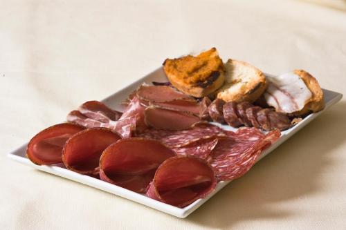 a plate of meat and bread on a table at Hotel Villa Ricci & Benessere in Chianciano Terme