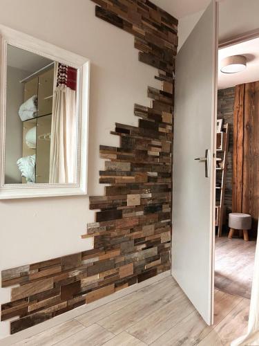 - un mur en pierre dans une pièce avec un miroir dans l'établissement Le Carrousel 4-6P Plein centre, à Gérardmer