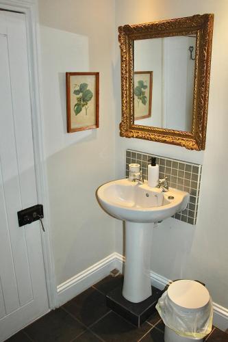 a bathroom with a sink and a mirror at Bessie May Cottage in Beaulieu